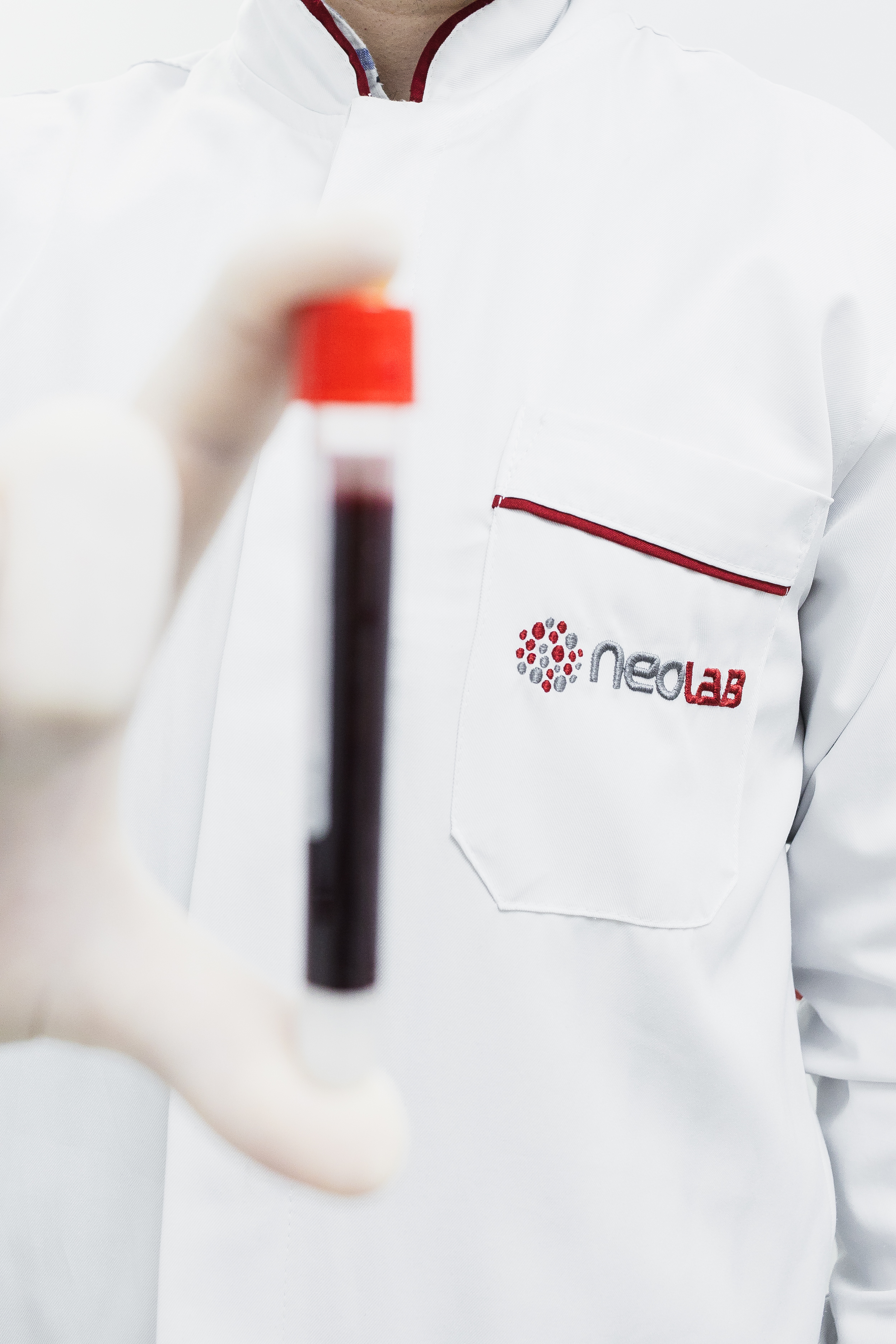Profissional do Neolab segurando um tubo de coleta